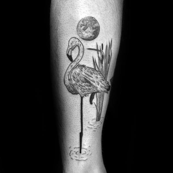 Black and grey flamingo tattoo with fine linework, moon, and reeds, creating a serene, nature-inspired design with a tranquil atmosphere.