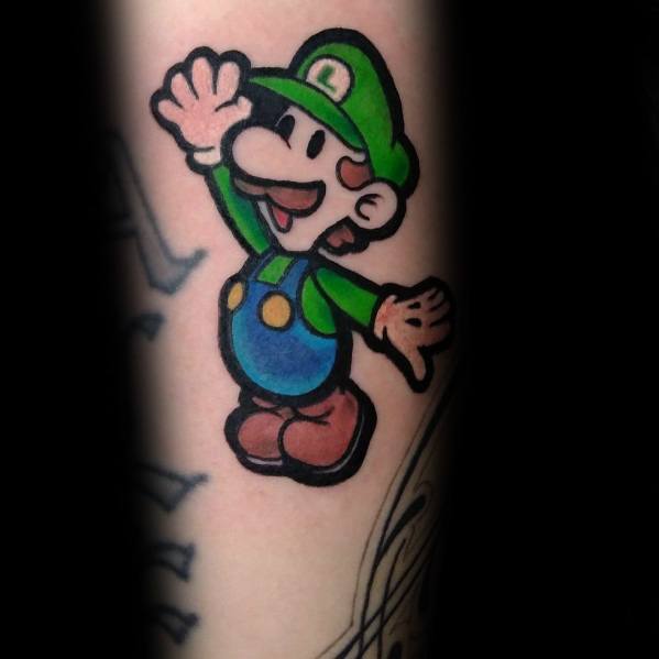 Tattoo of Baby Luigi in a playful pose, featuring bold outlines and bright colors, inked in a classic cartoon style on the arm.