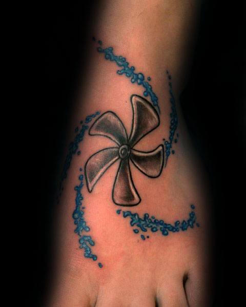 Colorful foot tattoo of a three-blade propeller surrounded by swirling blue water, featuring bold shading and dynamic motion effects for a nautical theme.