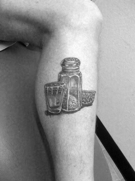 Realistic black and grey tattoo of a tequila shot glass, salt shaker, and lime wedge, creating a classic and detailed celebratory design.