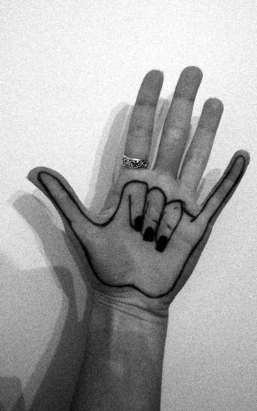 black ink tattoo outlining the "I love you" sign in American Sign Language, creatively placed on the hand to align with the real fingers
