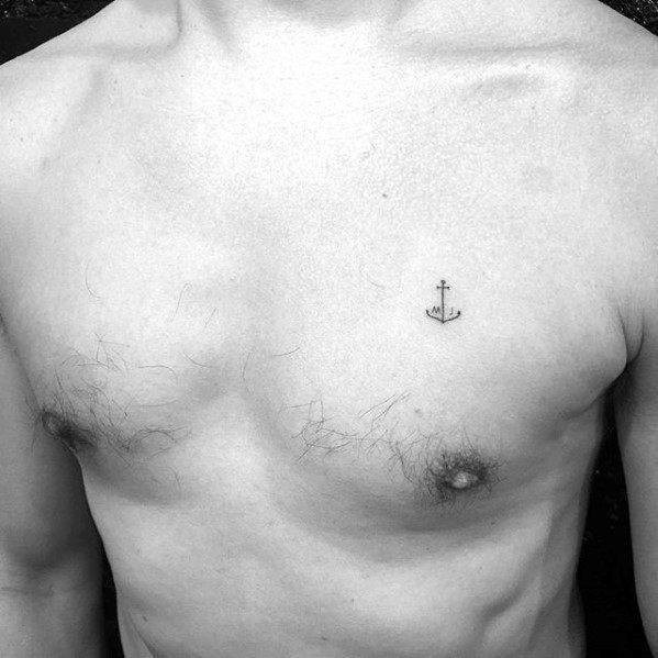 Tiny anchor tattoo on the chest with fine black lines, symbolizing stability, strength, and a personal connection to the sea or adventure.