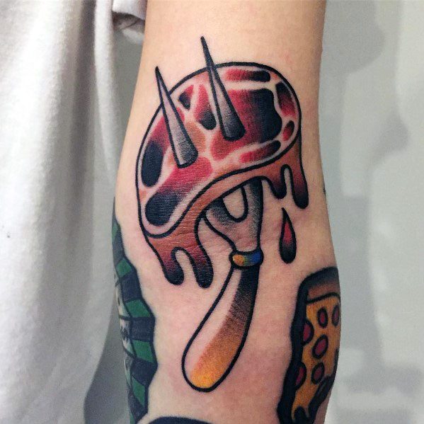 Tattoo of a dripping steak pierced by a two-pronged fork, featuring bold outlines, vibrant shading, and a classic traditional tattoo style.