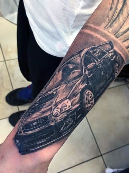 Realistic Subaru WRX STI tattoo on the forearm, featuring a detailed, high-contrast design of the car in motion with a dynamic perspective.