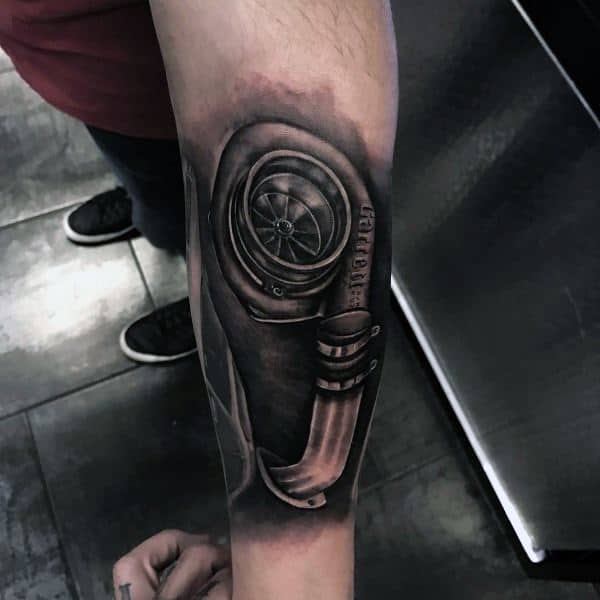 Realistic **Garrett turbocharger** tattoo on the forearm with intricate shading and metallic detailing, symbolizing speed, power, and a passion for automotive performance.