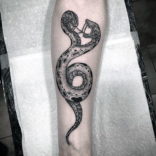 Black and grey two-headed snake tattoo on the forearm, featuring intricate shading and scale details for a bold and dynamic design.