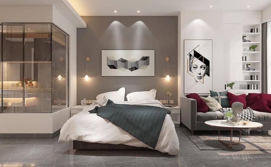 large luxury bedroom with gray sofa and glass ensuite 