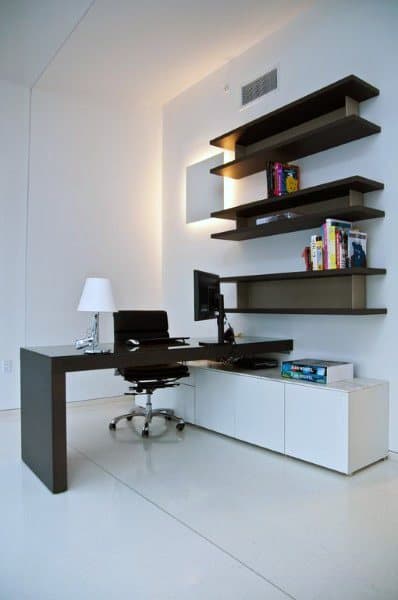 Minimalist home office with sleek desk, floating shelves, and white storage cabinets.