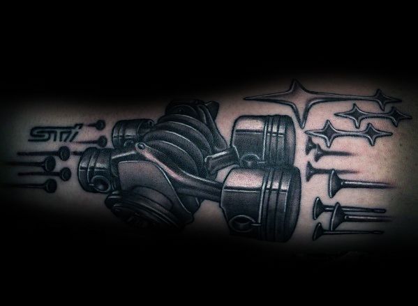Black and grey Subaru-themed tattoo featuring a detailed boxer engine, STI logo, Subaru stars, and valve components in a mechanical design.