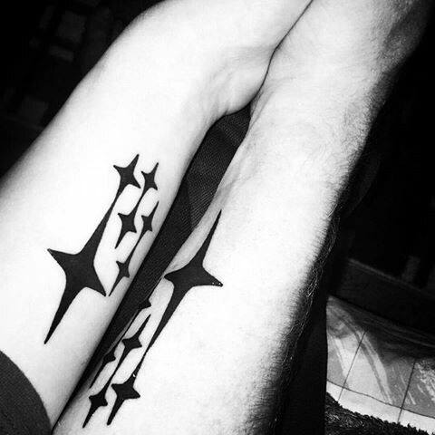 Matching black Subaru logo tattoos on the forearms, featuring the iconic six-star emblem in a bold, minimalist design.