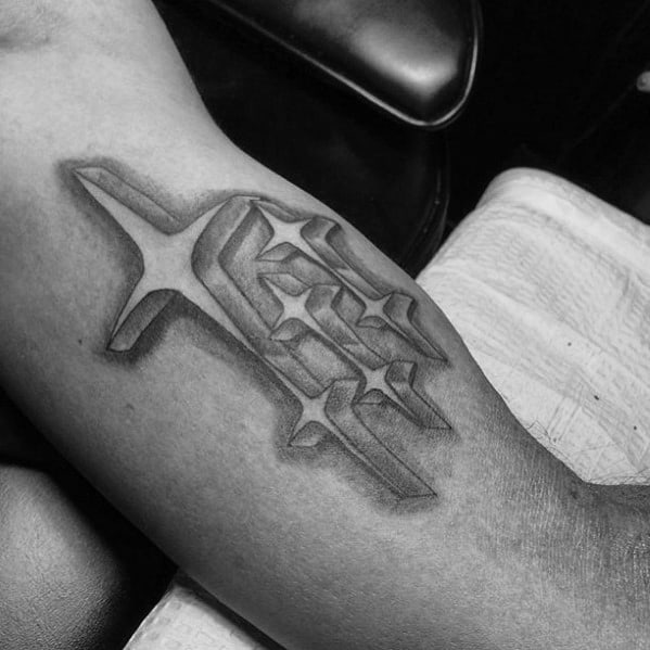 Black and grey Subaru logo tattoo with a 3D effect, featuring the iconic six-star emblem appearing to be embedded into the skin.