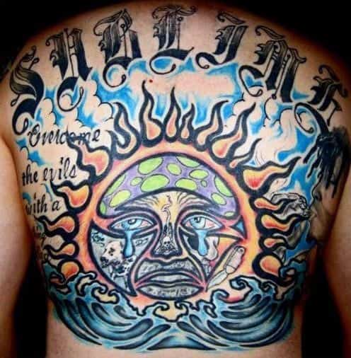 Vibrant full back tattoo with the Sublime sun face, ocean waves, flames, and the phrase “Overcome the evil with a...” above.