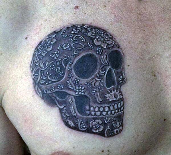 A detailed sugar skull tattoo on a person's shoulder