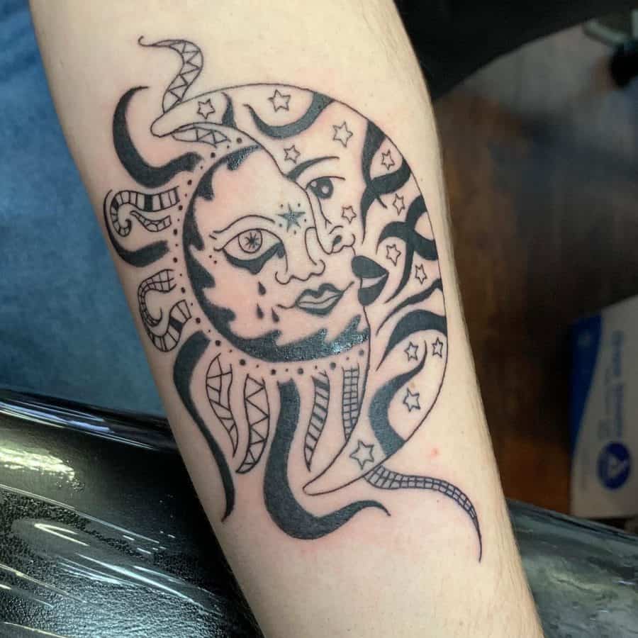 Black ink tattoo of a sun and moon with expressive faces, celestial stars, and intricate flowing patterns, creating a bold cosmic design.