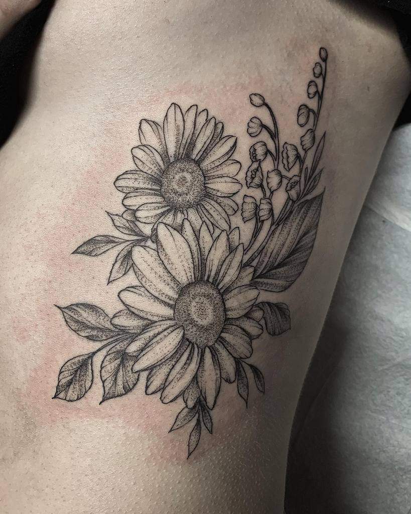 Black and grey floral tattoo featuring detailed daisies and Lily of the Valley, with fine shading and dot work for a soft, natural look