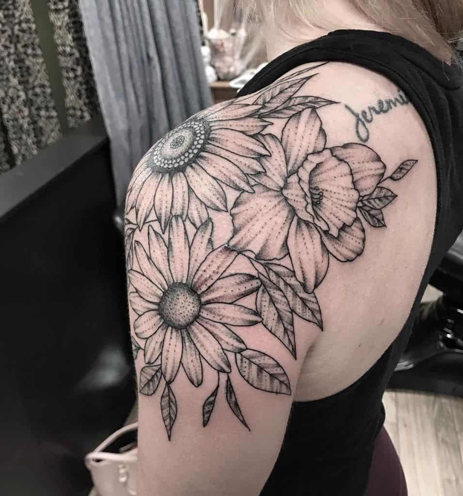 Shoulder wrapped tattoo large black and grey shading sunflower daisy and daffodil