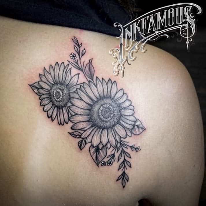 Tattoo of two sunflowers with detailed petals and leaves on a shoulder