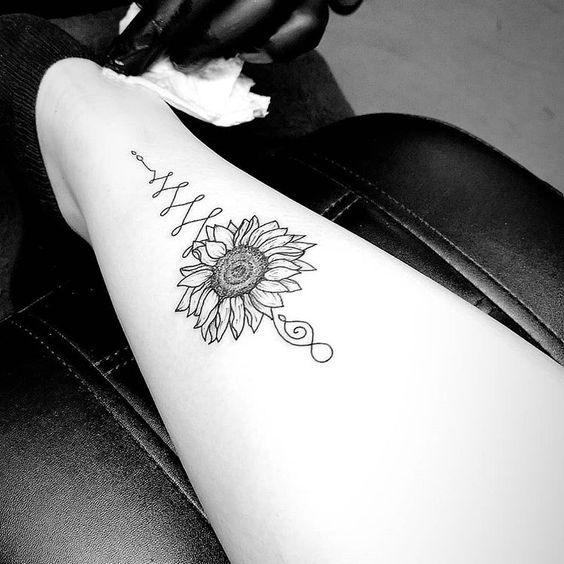 Unalome tattoo with a sunflower on the leg, symbolizing personal growth, positivity, and the journey toward enlightenment and inner peace.