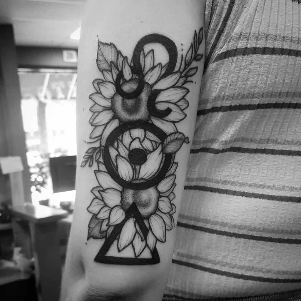 Elegant floral Leo tattoo with sunflowers and a fine-line zodiac symbol, blending astrology with nature.