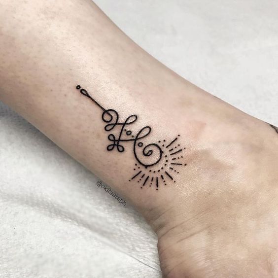 Unalome tattoo on the ankle with a sunburst design, symbolizing spiritual growth, enlightenment, and the journey toward inner peace.