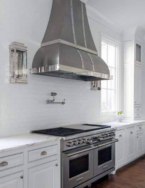 metallic kitchen hood with borders and white cabinets