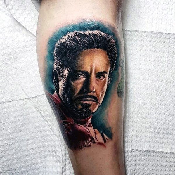 Iron Man tattoo featuring a hyper-realistic portrait of Tony Stark, capturing his intense expression and vibrant shading that brings his face and iconic red suit to life.
