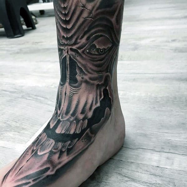 Tattoo of a dark, detailed skull covering the top of a foot and ankle