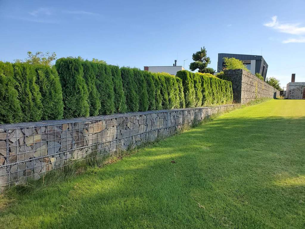 stone retaining wall garden hedges large grass lawn