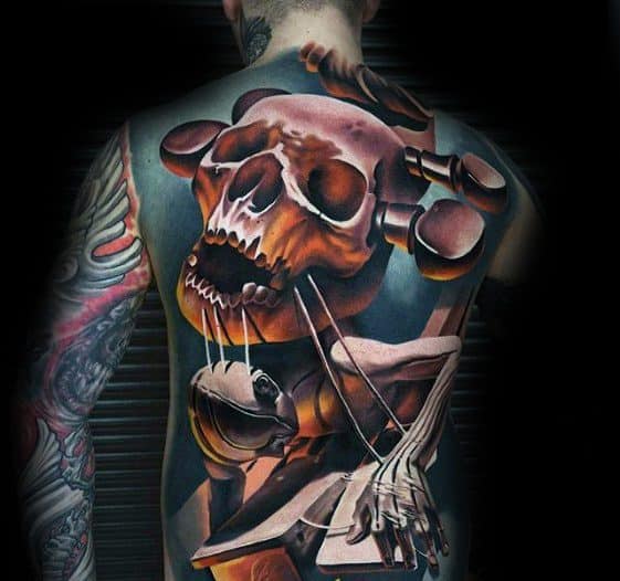 Surreal full back tattoo of a skull with strings controlling a marionette-like puppet, blending dark tones with bold geometric forms.