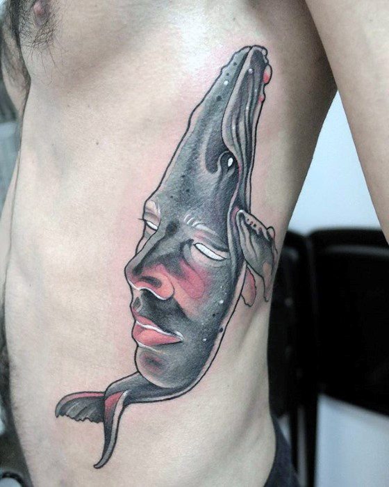 Surreal rib tattoo of a whale seamlessly merged with a human face, blending marine life and emotion in a flowing abstract style.