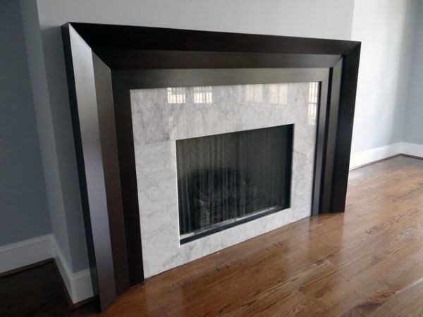 A modern fireplace with a sleek wood frame and marble surround, creating a refined and minimalist focal point.