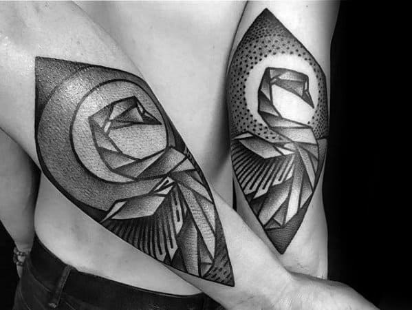Matching geometric swan tattoos on forearms, featuring bold black lines, dotwork shading, and angular patterns within diamond-shaped frames.