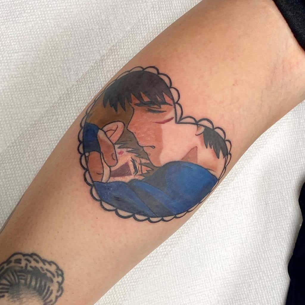 Colorful tattoo of a couple embracing, depicted inside a heart-shaped frame, with soft shading and gentle details.