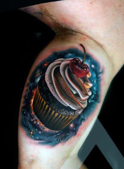 Realistic tattoo of a chocolate cupcake with swirled frosting and a cherry on top, featuring rich colors and a glowing cosmic background.