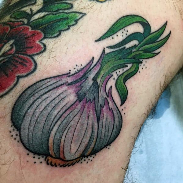 Colorful garlic tattoo with bold outlines, smooth shading, and vibrant green leaves, creating a striking and dynamic botanical design.