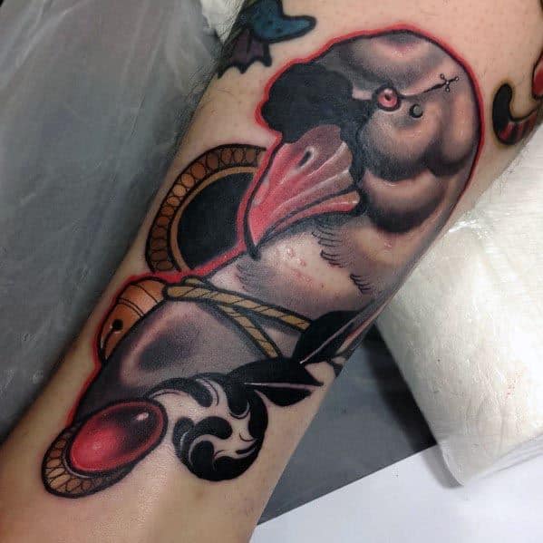 Bold neo-traditional tattoo of a goose with dramatic shading, a rope, and ornamental elements, inked with rich colors and strong outlines on the forearm.