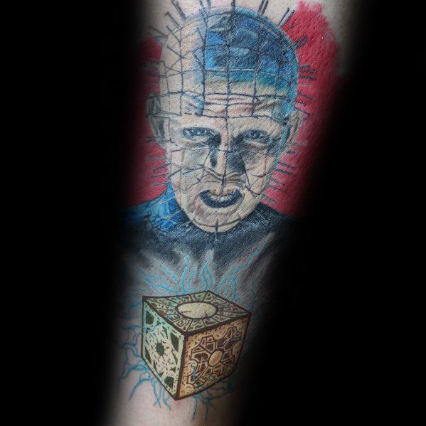 Color *Hellraiser* tattoo of Pinhead with a glowing Lament Configuration, featuring eerie blue tones, red background, and electric energy effects.