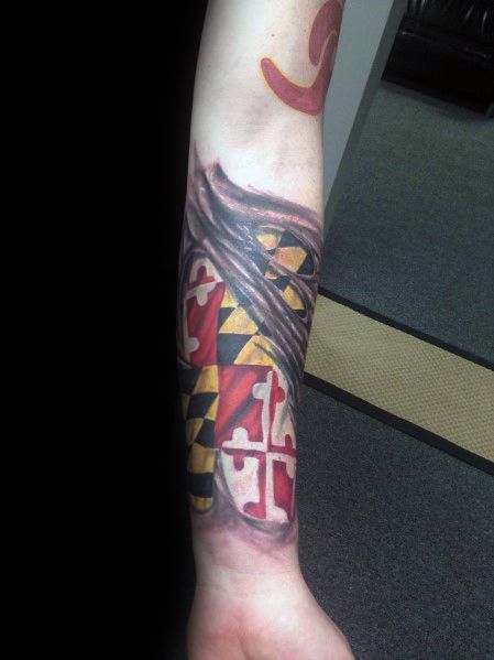 Maryland flag tattoo on the forearm with a ripped skin effect, creating a bold 3D illusion of the flag beneath wrapped in realistic shading.