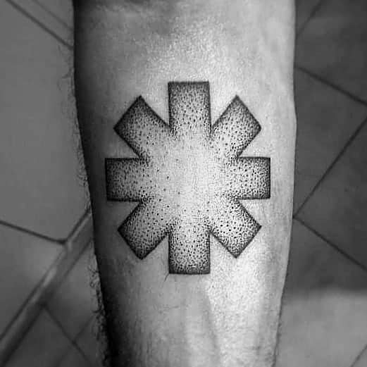 Forearm tattoo featuring the Red Hot Chili Peppers logo with detailed dotwork shading, creating a bold yet minimalist black and grey design.