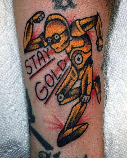 Playful C-3PO tattoo in a dynamic running pose with bold lines, red accents, and "Stay Gold" lettering for a fun, retro style.
