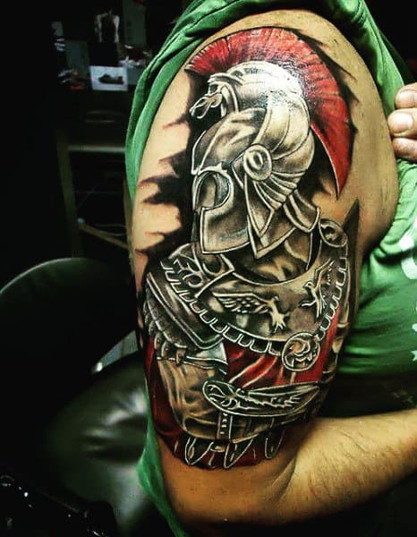 A detailed tattoo of a Roman soldier, resembling a gladiator in armor with a red plume, adorns the upper arm