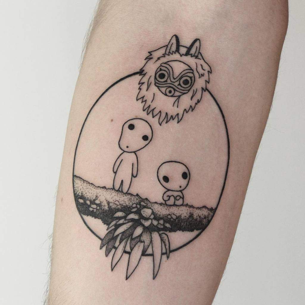 Minimalist black ink tattoo of kodama spirits and Moro’s wolf mask within a circular frame, with a nature-inspired base and detailed lines.
