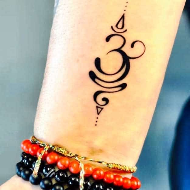 Tattoo of an Om symbol on an arm, reminding one to breathe and find inner peace