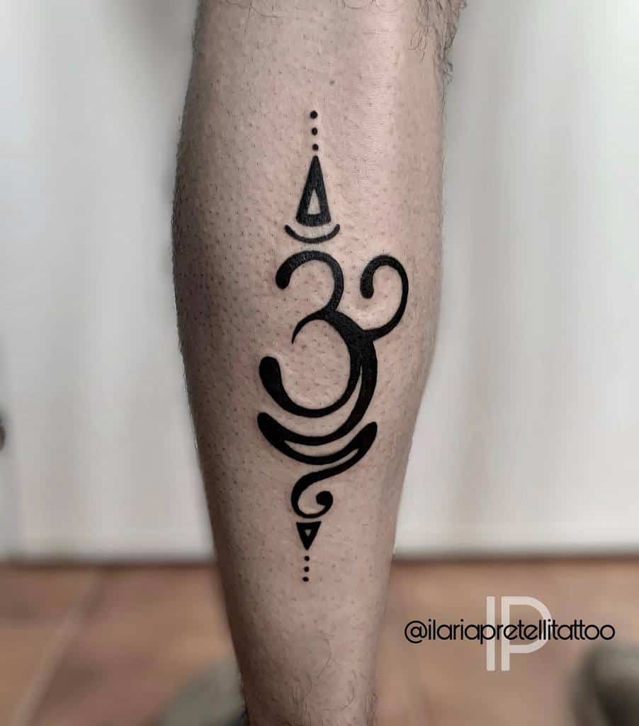 A tattoo of an Om symbol graces the leg, accompanied by decorative dots and a spiral at the bottom, serving as a gentle reminder to breathe