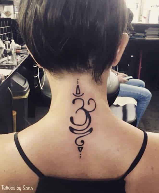 Intricate Om symbol tattooed on the back of the neck with geometric accents and curved lines, designed in bold black ink