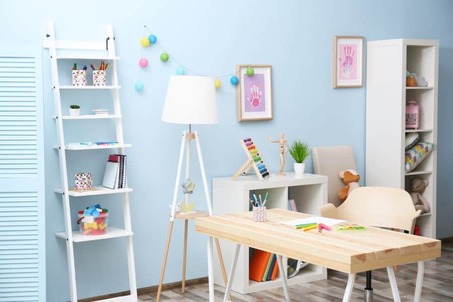 blue wall kids room with table and storage options