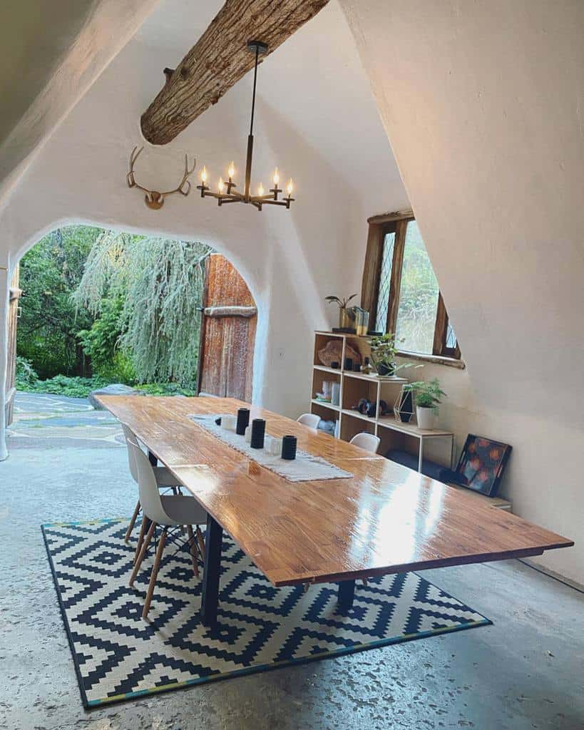 long wood dining table high ceilings chandelier concrete floor