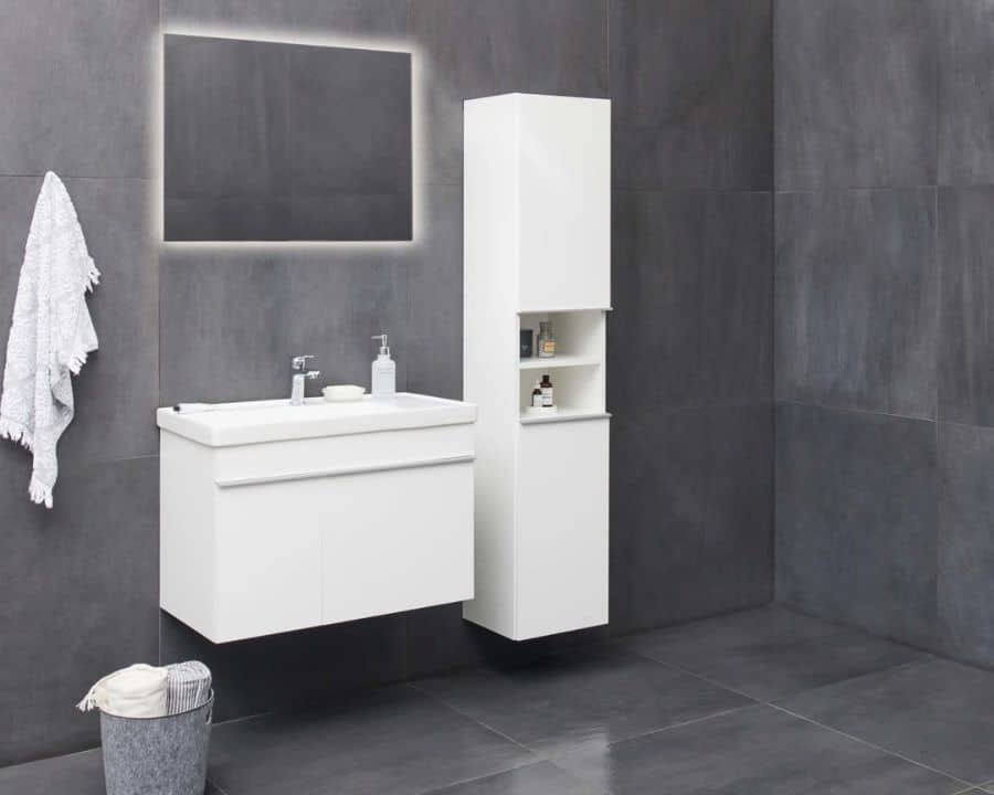 Modern bathroom with large dark tiled walls, white floating vanity, and slim open-shelf tall cabinet.