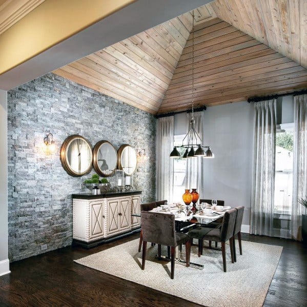 Elegant dining room with vaulted wood ceiling, stone accent wall, and modern decor.