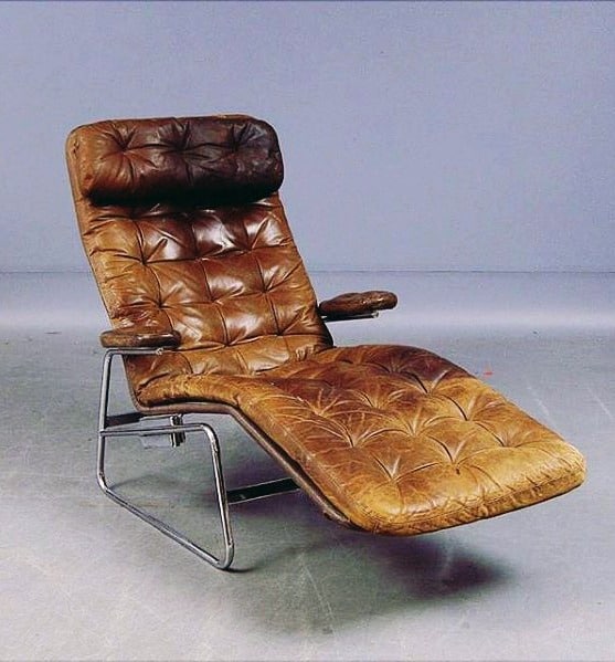 Vintage tufted tan leather recliner chair with chrome frame.